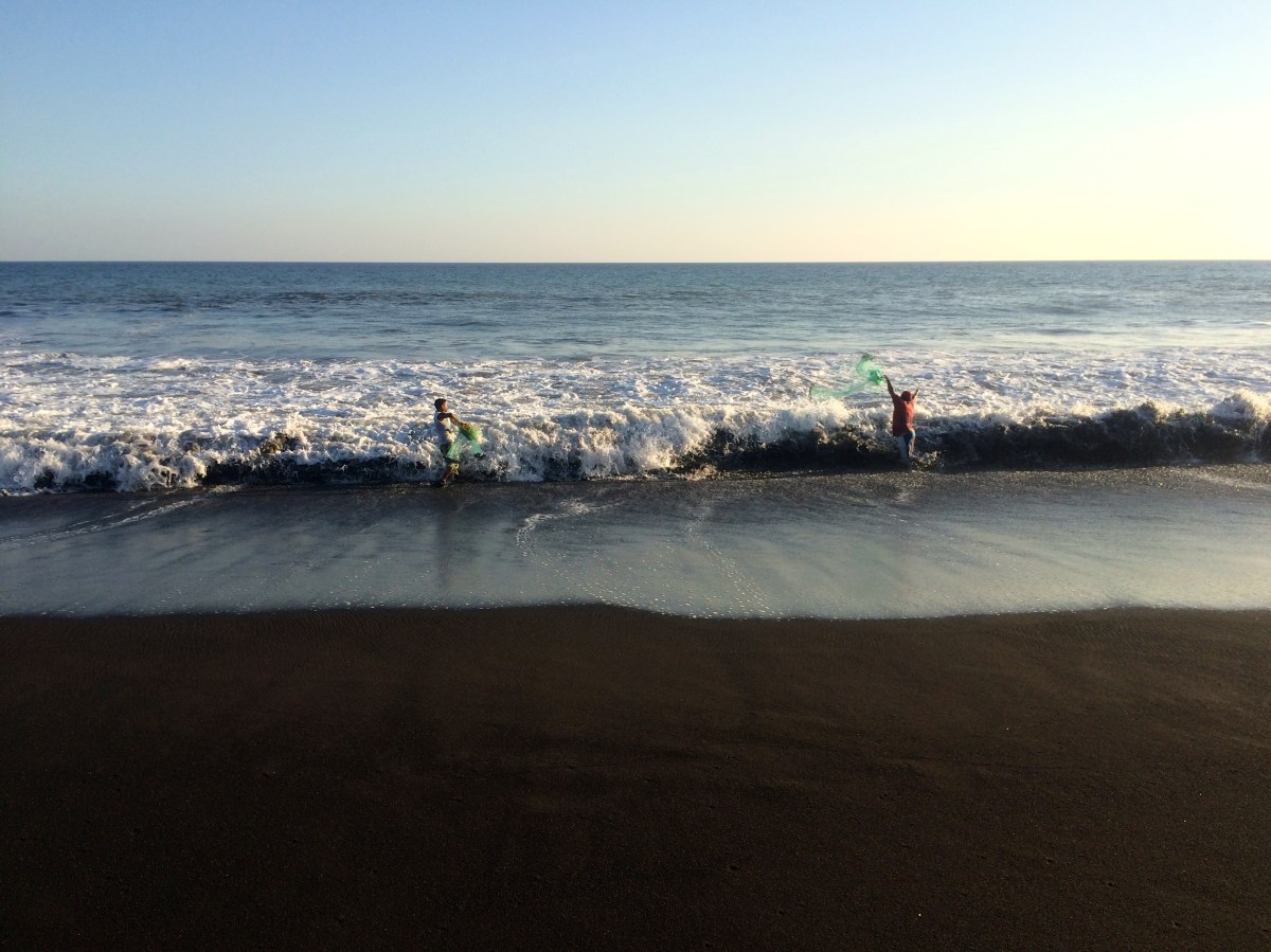 Fisherman throw nets over the Pacific waves -- Karina Noriega