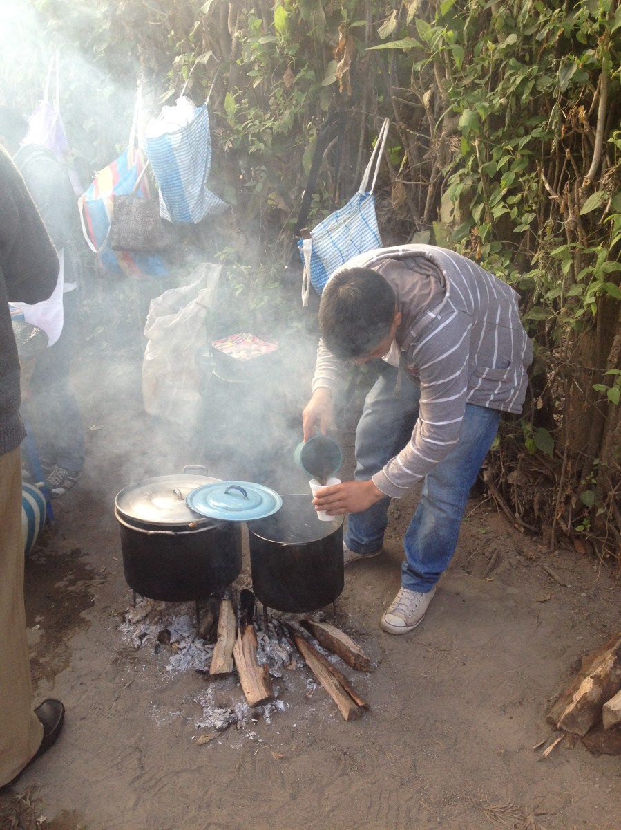 A young boy boiling water for coffee over open fire. Antigua, Guatmala -- April Beresford